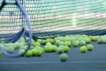 Tennis racket with tennis balls on a court