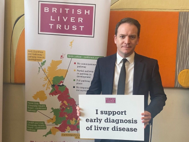 Gareth Davies MP holding a sign in support of the early diagnosis of liver disease