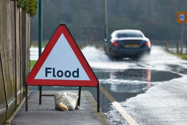 Road sign in floodwater reading "Flood"
